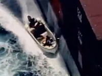 ソマリアの海賊たちが大きな貨物船を乗っ取ろうとしているシーンの映像。