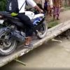 インドで集中豪雨、崩れた道路に丸太で架けられた小さな橋を青年がバイクで渡ろうとするが…