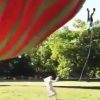 熱気球が突然上昇して熱気球とロープで繋がっていた男が宙ぶらりになる