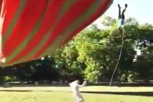 熱気球が突然上昇して熱気球とロープで繋がっていた男が宙ぶらりになる