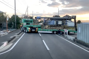 【滋賀】立ち往生して30分以上県道を塞いでしまった大型トレーラーが最終的に看板とポールを破壊して脱出する様子。