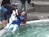 これは大損害・・・。噴水に落とされた女性⇒を撮影しようとしたカメラマンが・・・。