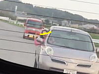 車から半身出しで何かを叫びながら追跡してくる危なそうなおばさんが撮影される。