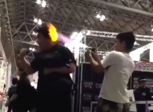 これは逮捕だろ。漫画雑誌のイベント会場で人の頭に向けて火炎放射する動画がバカッター。