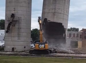 予想通りの事故。サイロ崩しに失敗して命を失いかけた重機のオペレーターさん。