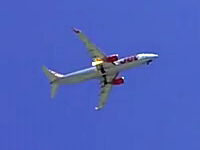 右エンジンから火を吹きながら飛行しているボーイング737-800型機の映像