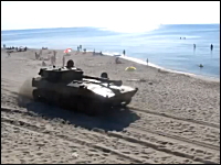 おそロシア。海水浴客で賑わうビーチをロシア軍の装甲車両の一団が通過。