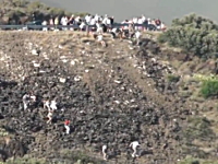 山火事から逃げるために車を捨てて急斜面を下る人々。スペインカタルーニャ