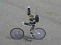 止まる時は足ブレーキ。自転車に乗った二足歩行ロボットがなかなか凄い。